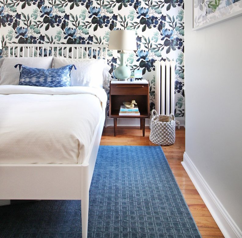 Blue area rug under a white bed in a tropical bedroom